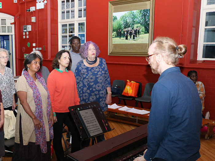 choir rehearsing with director on piano